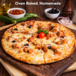 Baked chicken pizza with olives, onions, and melted cheese on a wooden board